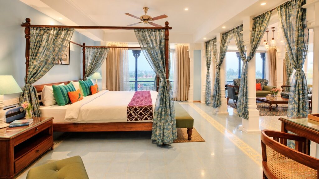 A luxurious brick resort villa with a manicured green lawn, lit up beautifully during a vibrant sunset.