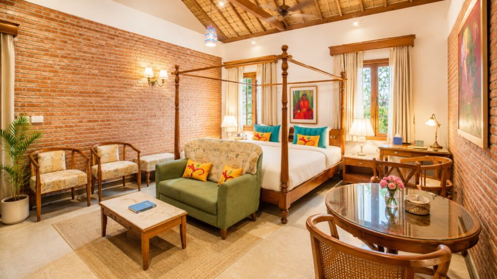 A luxurious brick resort villa with a manicured green lawn, lit up beautifully during a vibrant sunset.