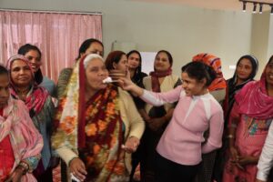 Women dressing each other during Women's Day celebration at Namaste Dwaar